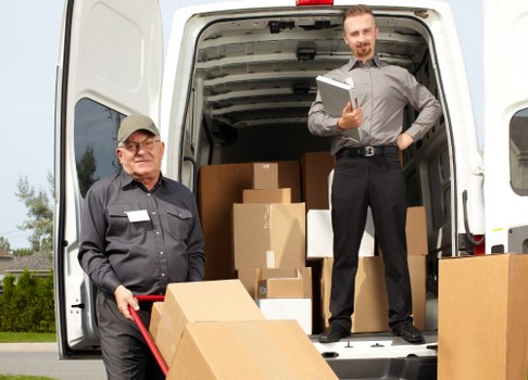Removal team carrying boxes with safety equipment in Croydon